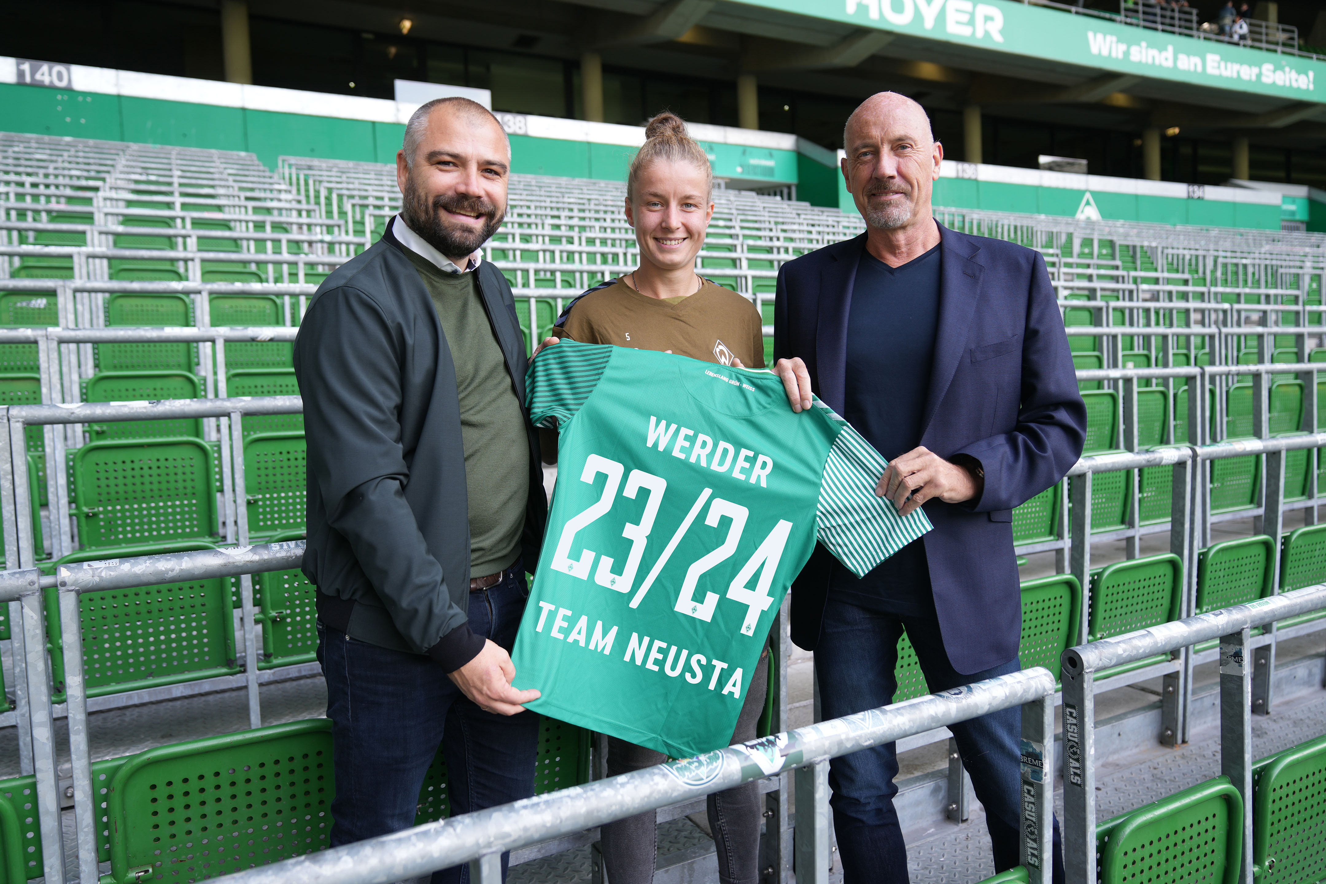 Carsten Meyer-Heder, Christian Rauhut und Spielerin bei SV Werder Bremen halten Trikot hoch 