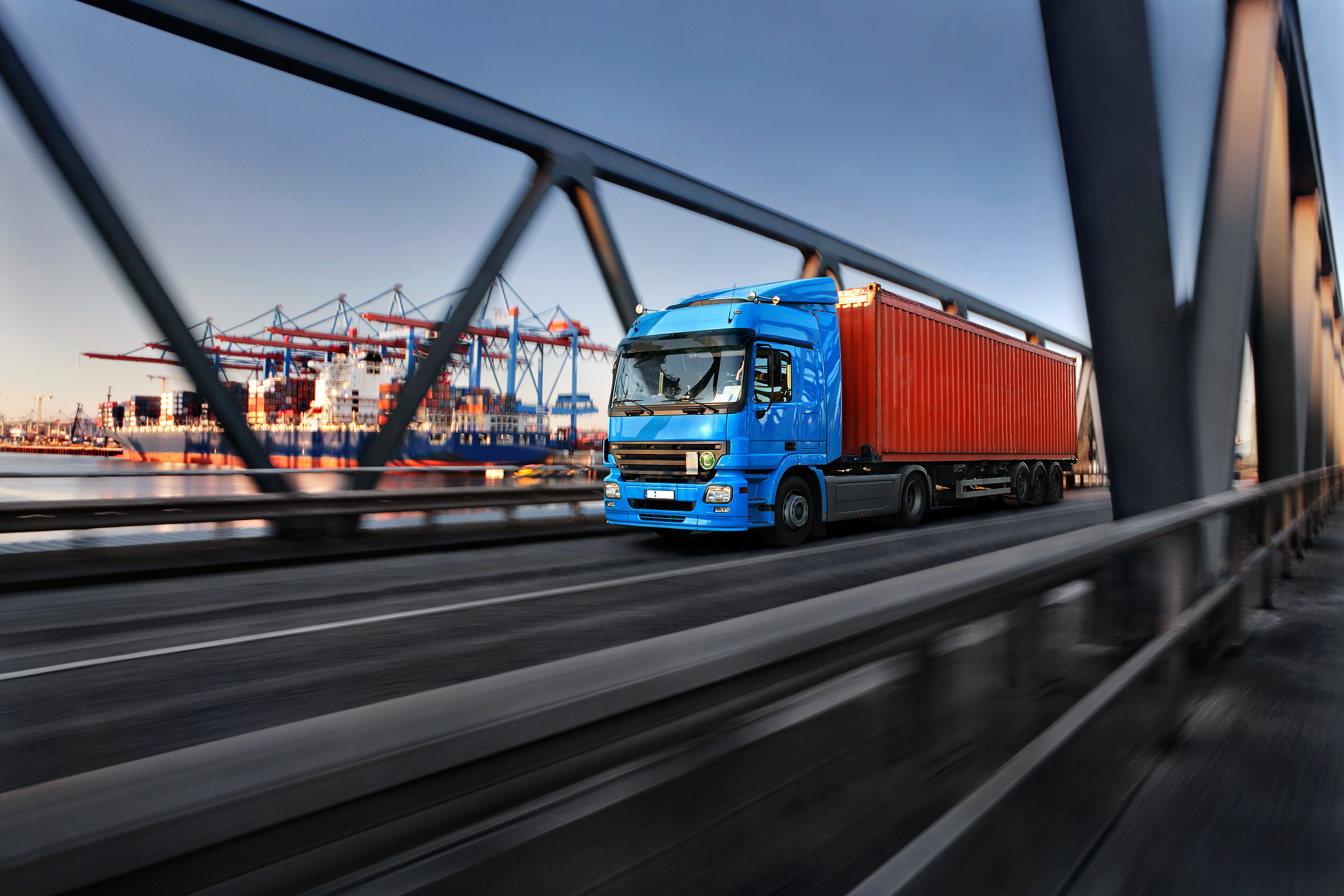 LKW fährt Container über eine Brücke für Logistik