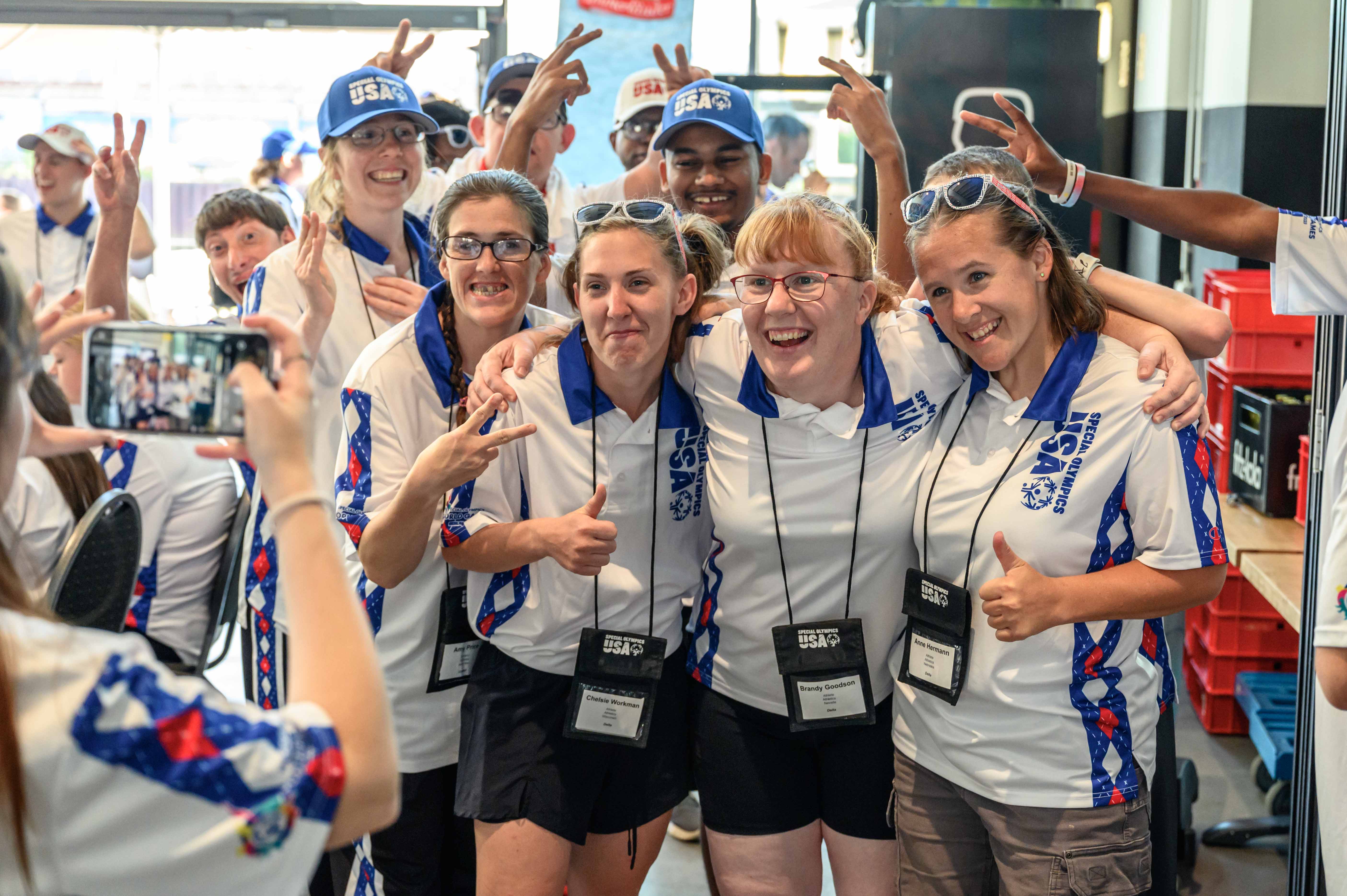 Mehrere Sportlerinnen der Special Olympics posen für ein Foto Arm in Arm