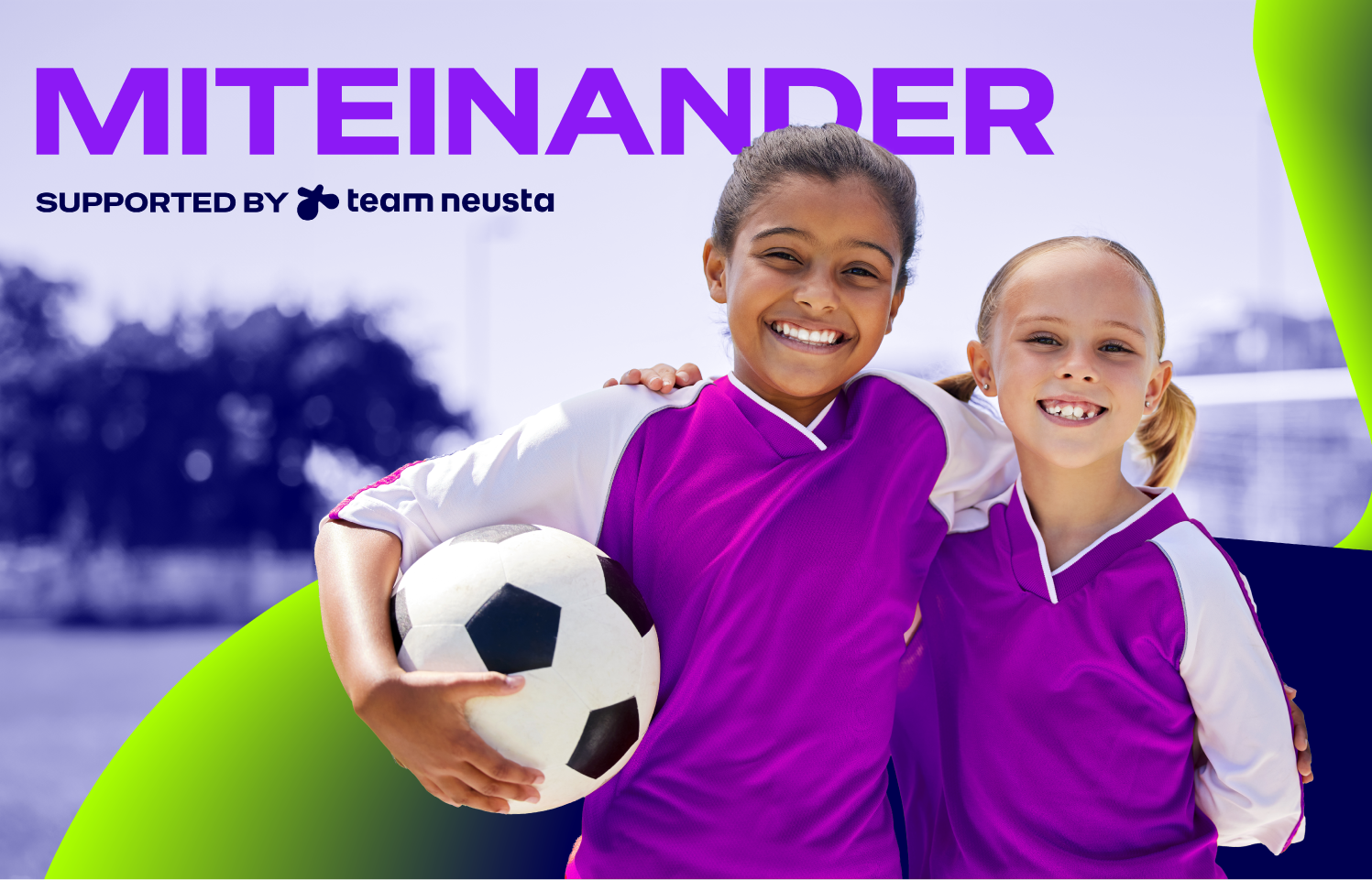 Zwei Mädchen in lila Fußballtrikots stehen lächelnd auf einem Sportplatz, eine hält einen Fußball; Banner mit dem Text ‚MITEINANDER – supported by team neusta‘, Thema Teamgeist und Nachwuchssport