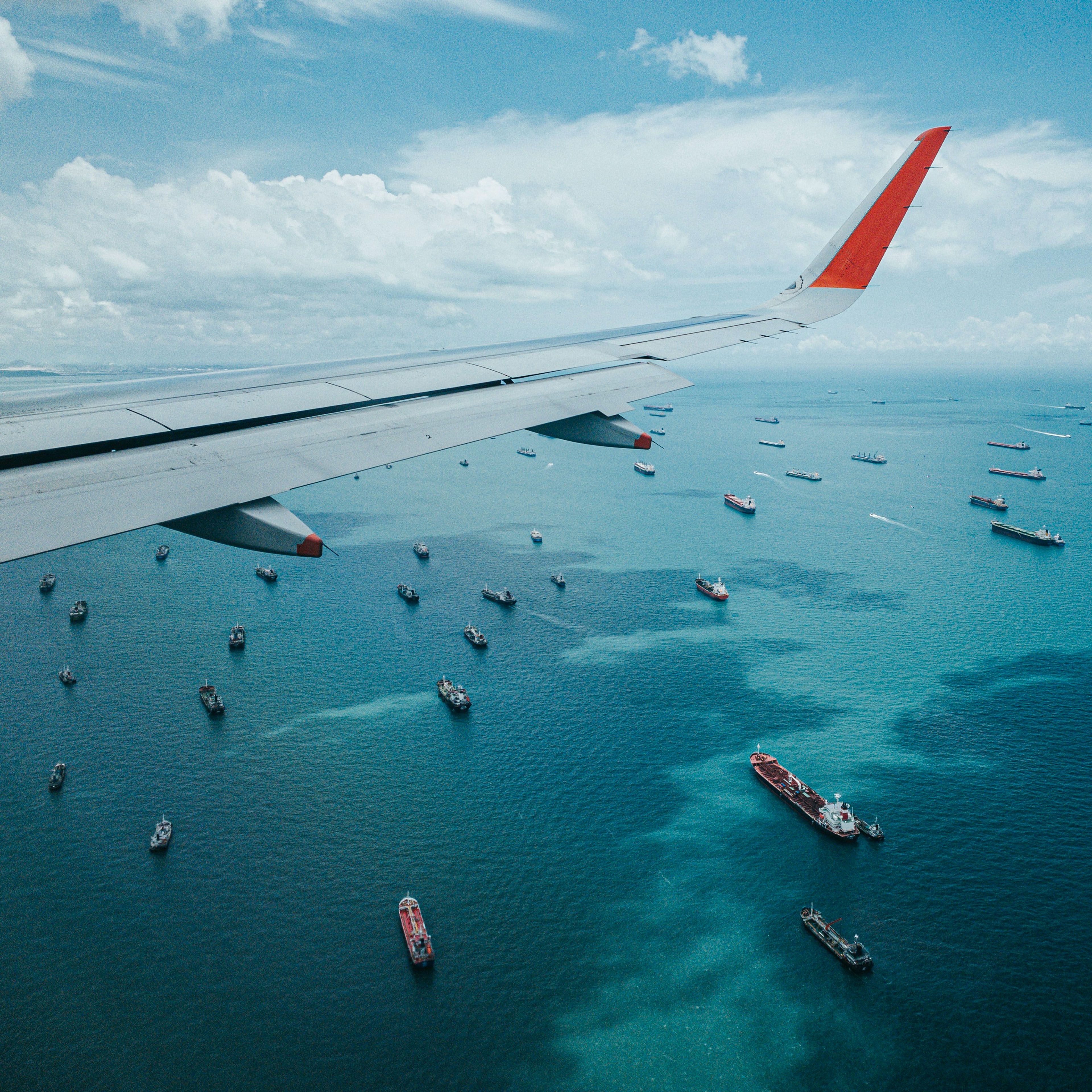 Flugzeug von oben mit Blick auf Meer auf dem Containerschiffe fahren