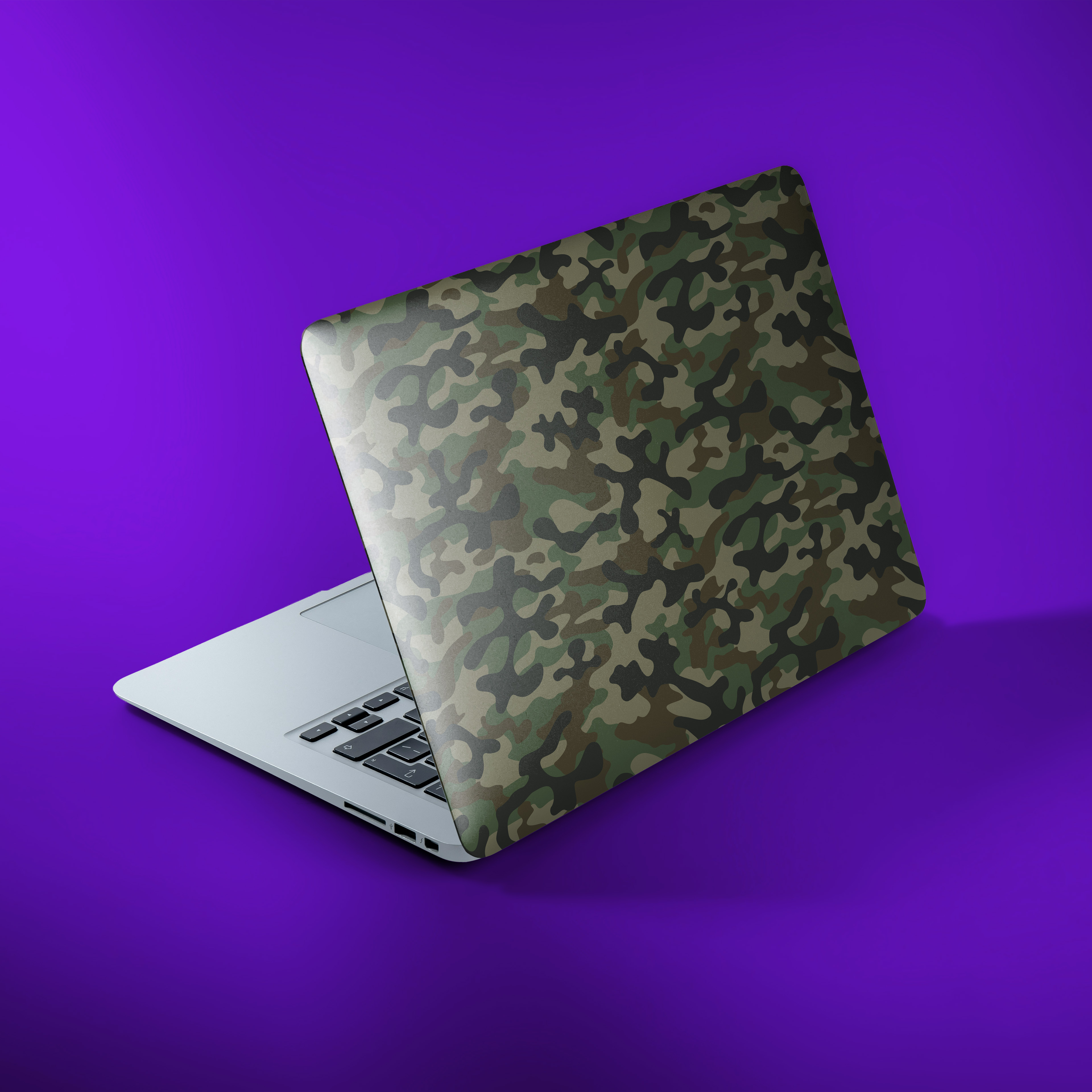 Aufgeklappter Laptop mit Tarnmuster auf lila Hintergrund