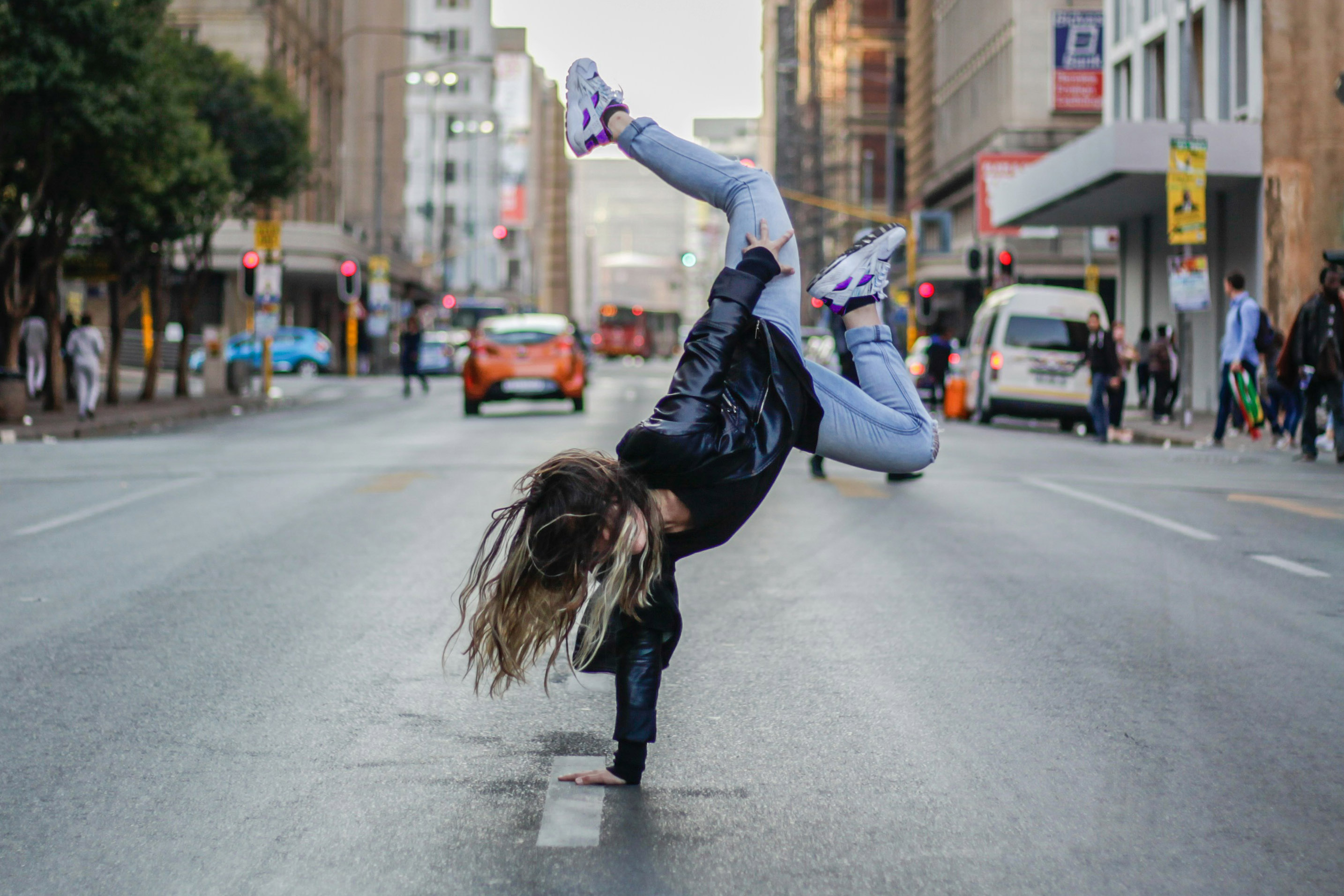 Frau macht auf der Straße einen Handstand