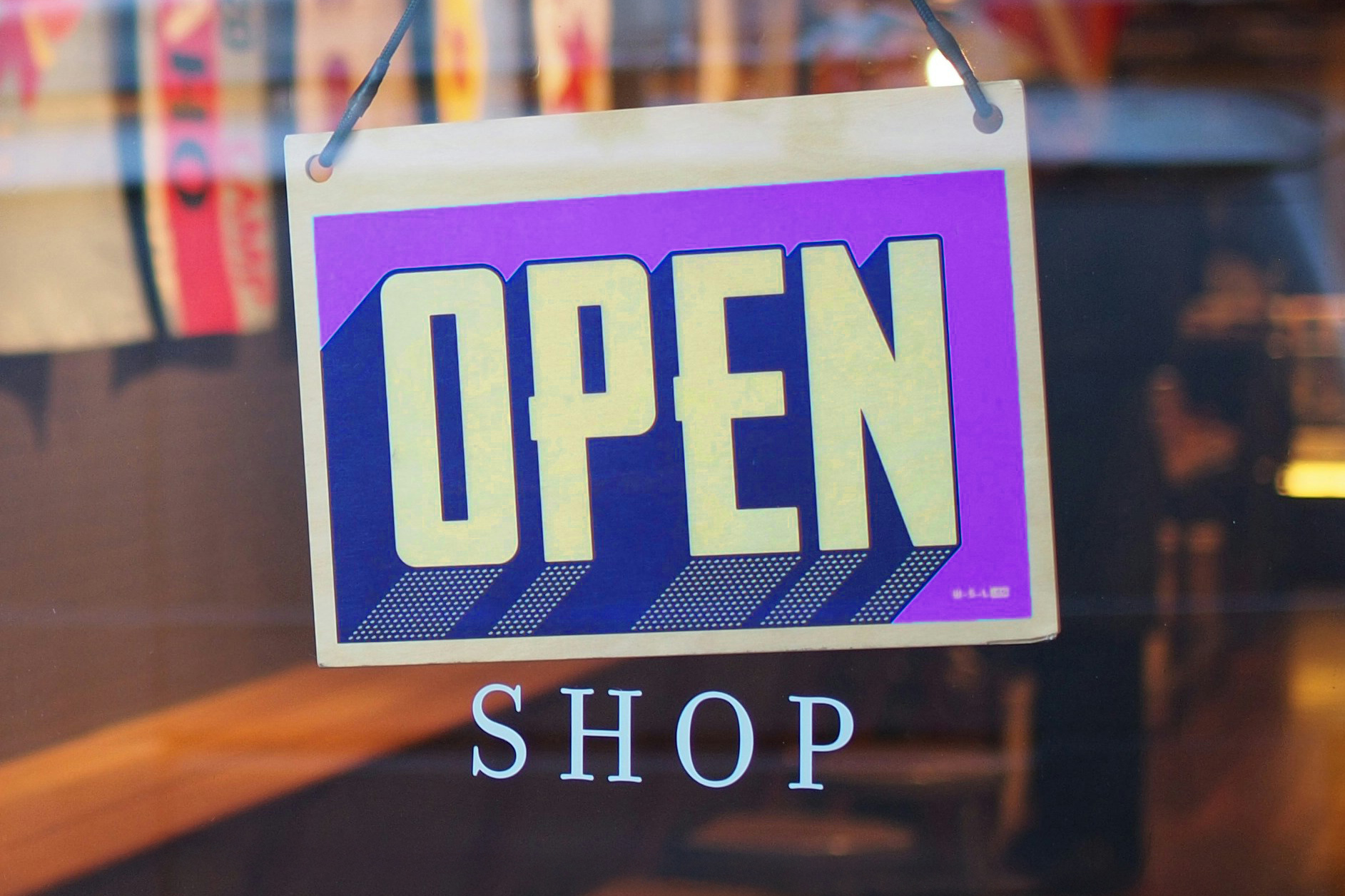 Schild an der Tür eines Ladens mit der Aufschrift "geöffnet" auf englisch