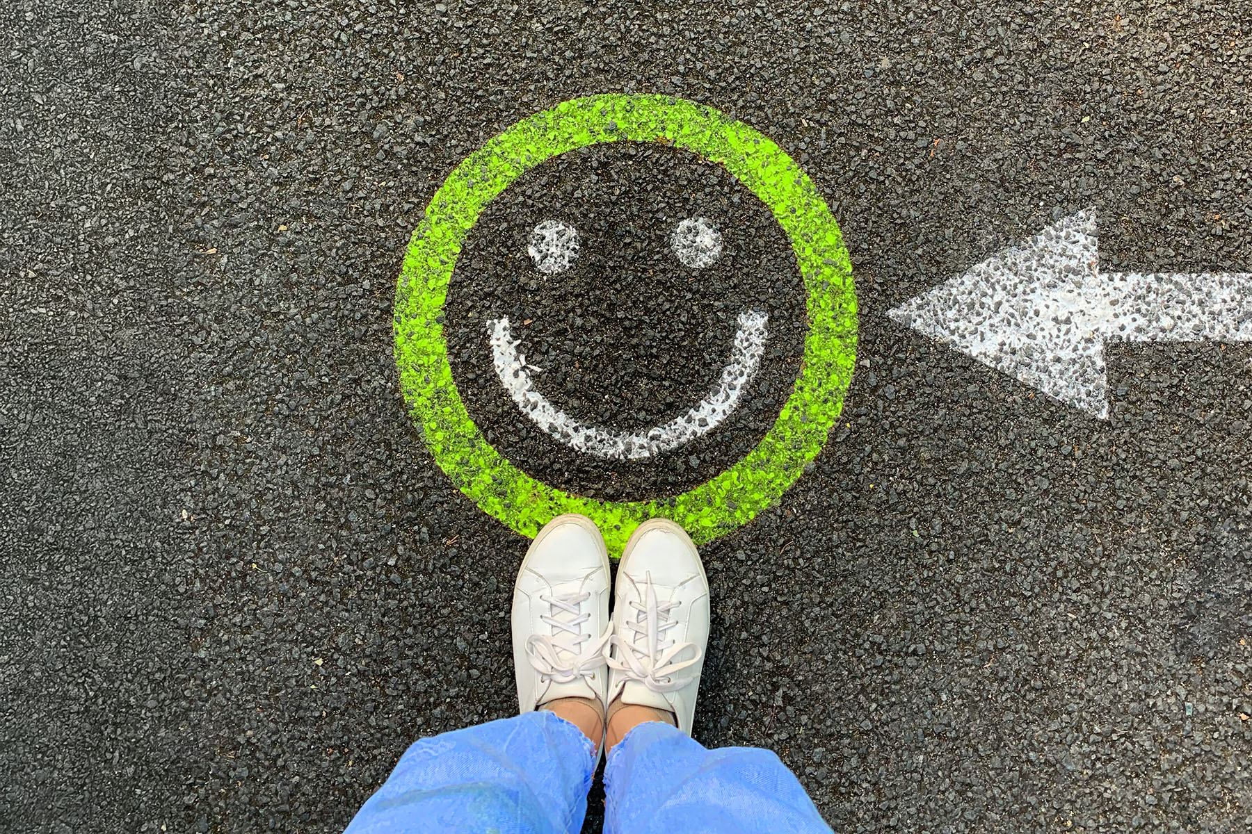 Smiley der mit grüner Kreide auf die Straße gemalt wurde