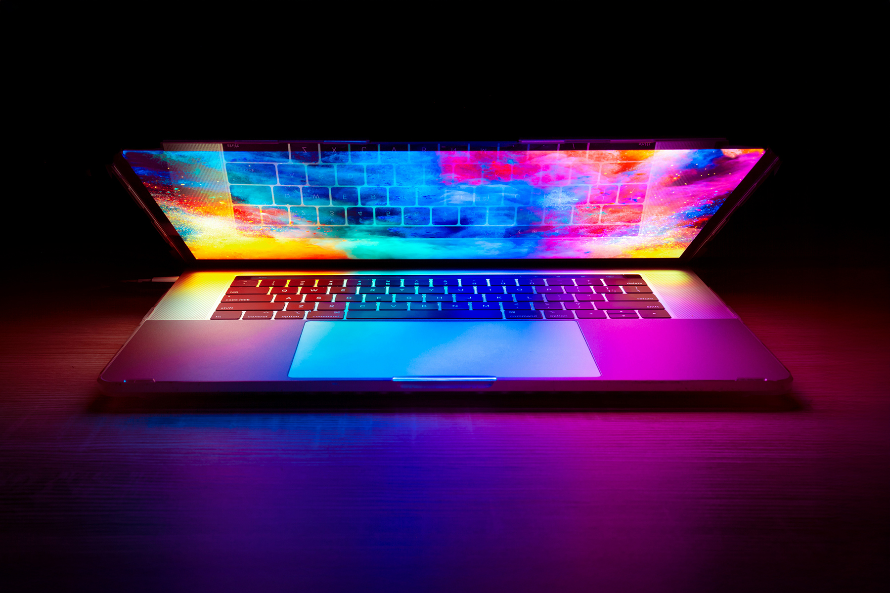 Laptop halb zugeklappt mit bunten Illustrationen auf dem Bildschirm