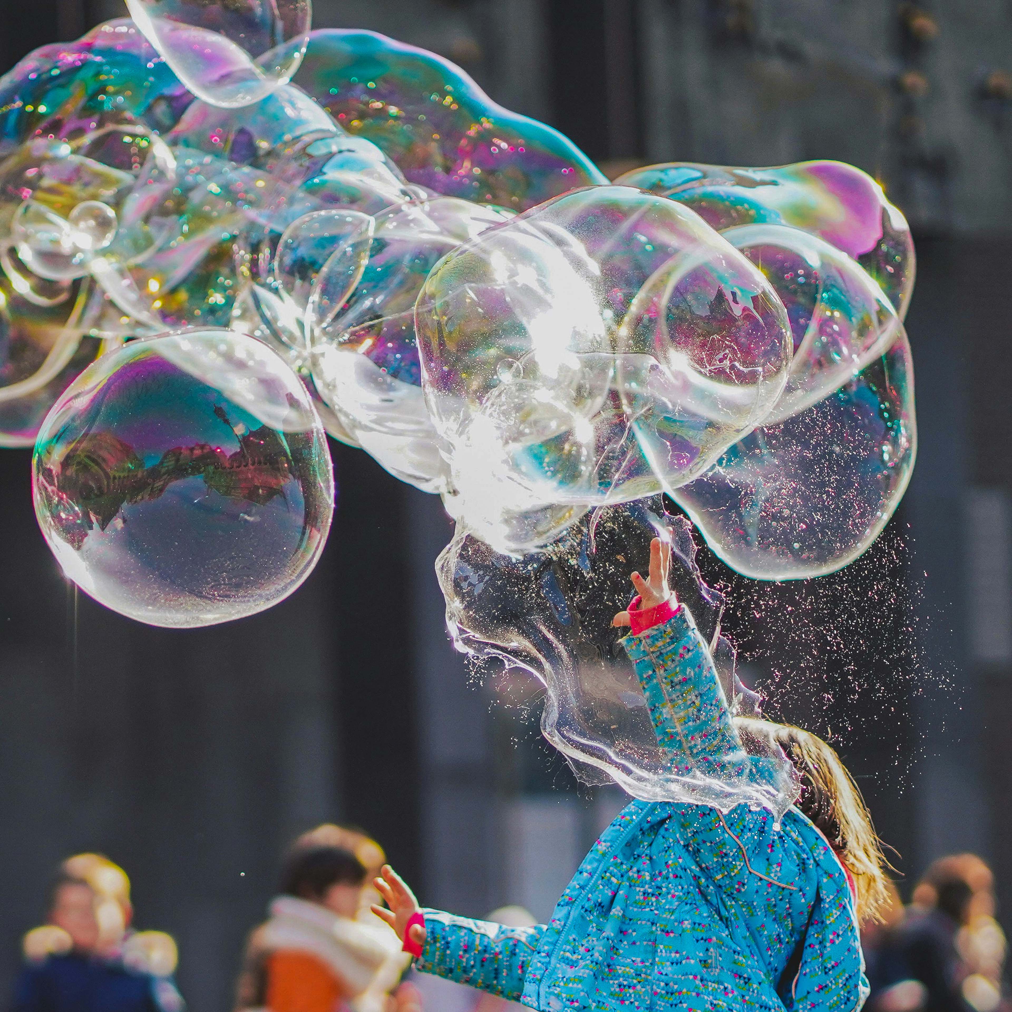 Kind spielt mit großen Seifenblasen