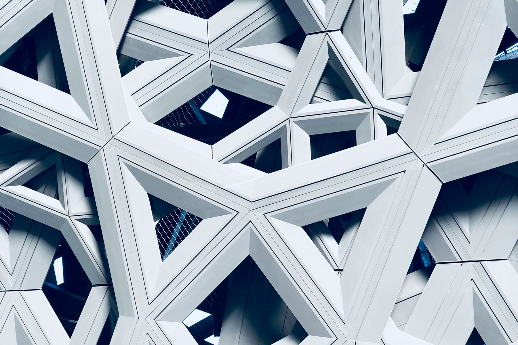 Geometrische, weiße Architekturstruktur mit verschachtelten Dreiecksformen