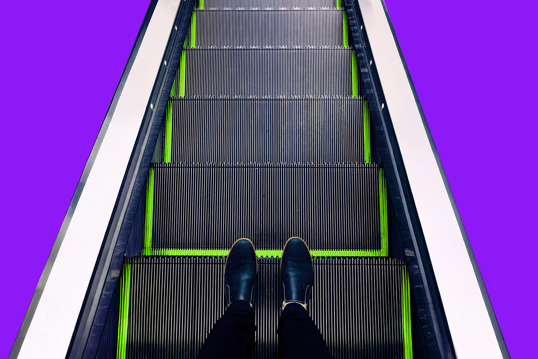 Füße stehend auf einer Rolltreppe aus der Vogelperspektive