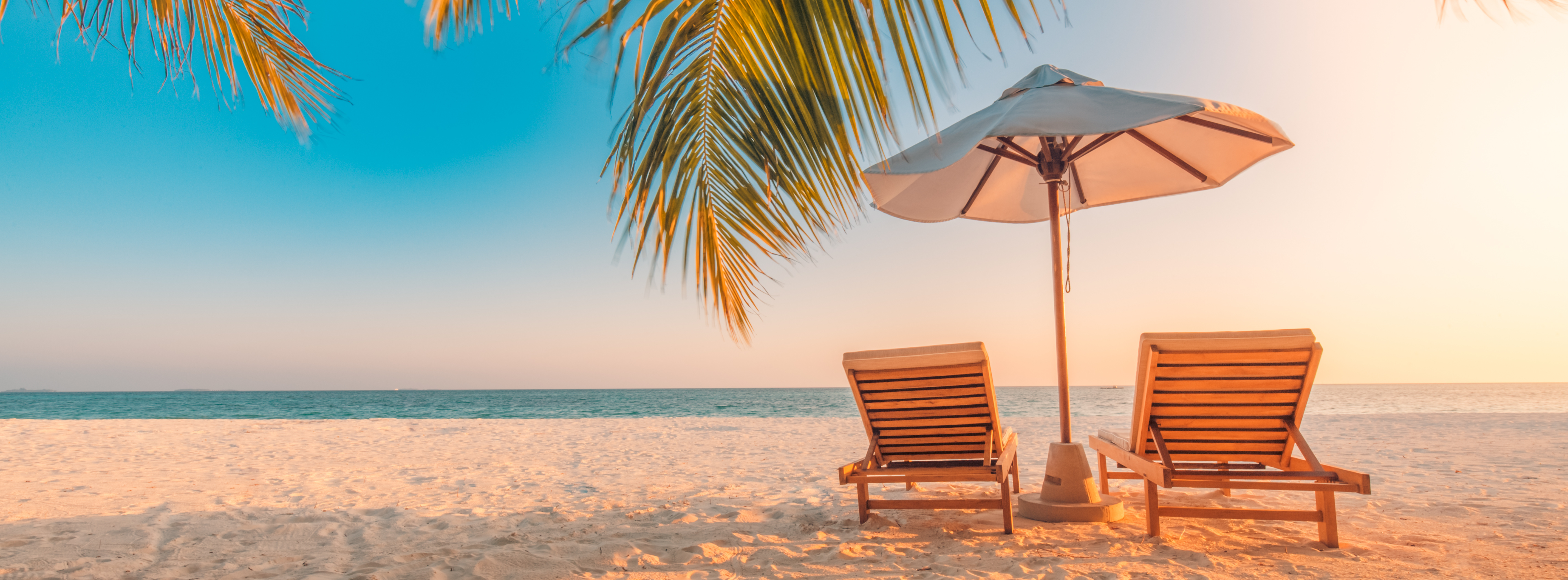 Corona Reise Check und zwei Liegen mit Sonnenschirm am Strand